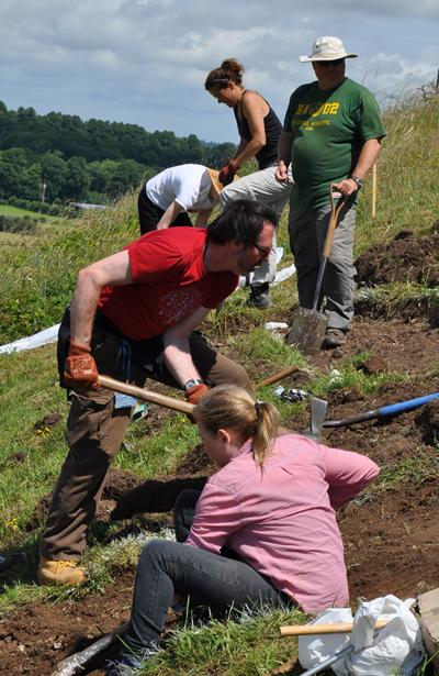 Students and volunteers cutting turf.